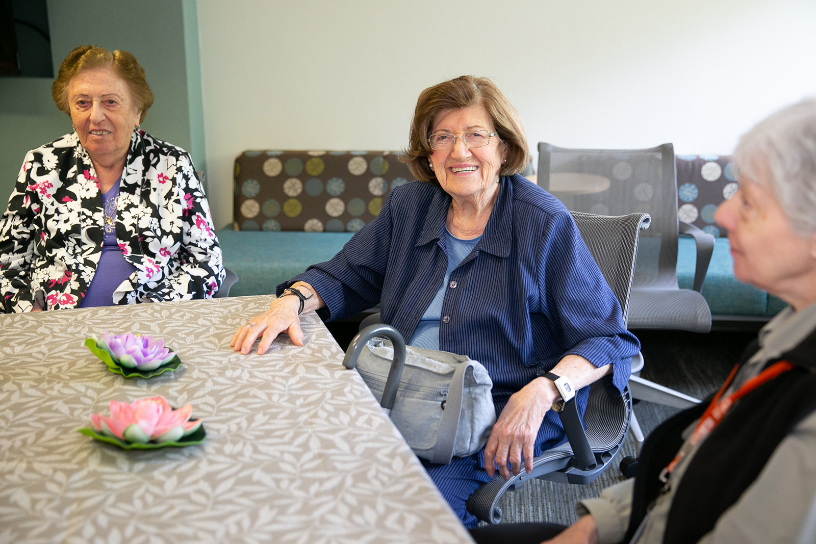 Three women are gathered around the table for our Let's Get Together program