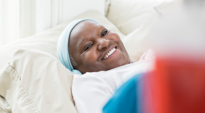 Older adult lying in hospital bed smiling