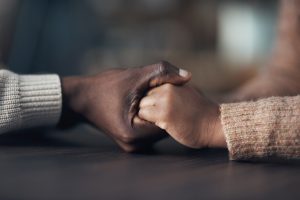 "close-up two people hold hands"