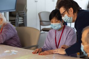 ADP staff member assists client with a game using the Lucynt magic table