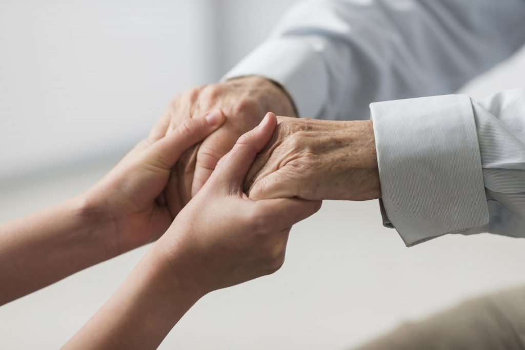 woman holding senior man's hands