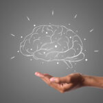 "Brain illustration in chalk, hand underneath"