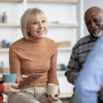 "Seniors sitting and chatting, having cups of tea"