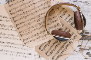 "flatlay headphones on top of sheet music"