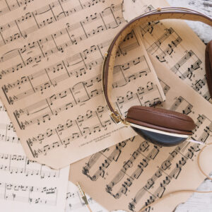"flatlay headphones on top of sheet music"