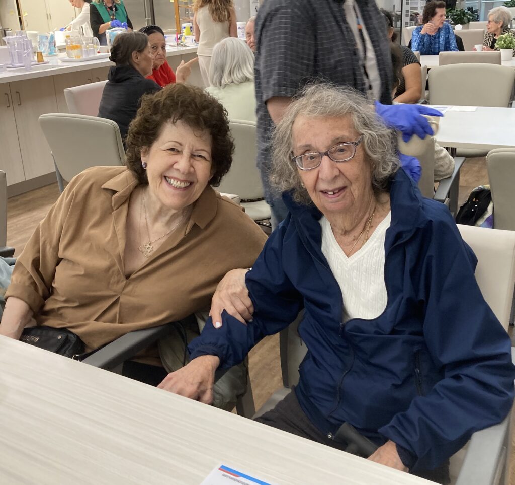 Two seniors sitting together and smiling.