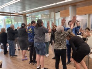 SALC program participants playing a game where two people make a bridge by raising their arms, and people walk under their arms. 