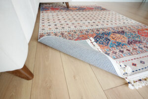 "throw rug curled on wooden floor"