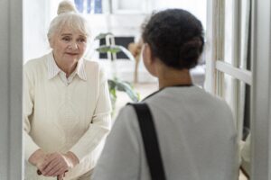 "A younger person checking in on a senior person at their house."