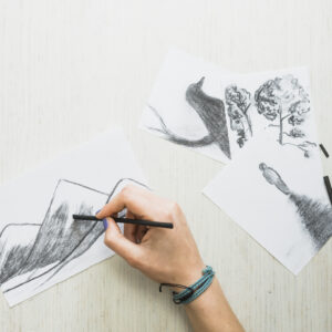 "hand sketching black drawing on white paper"